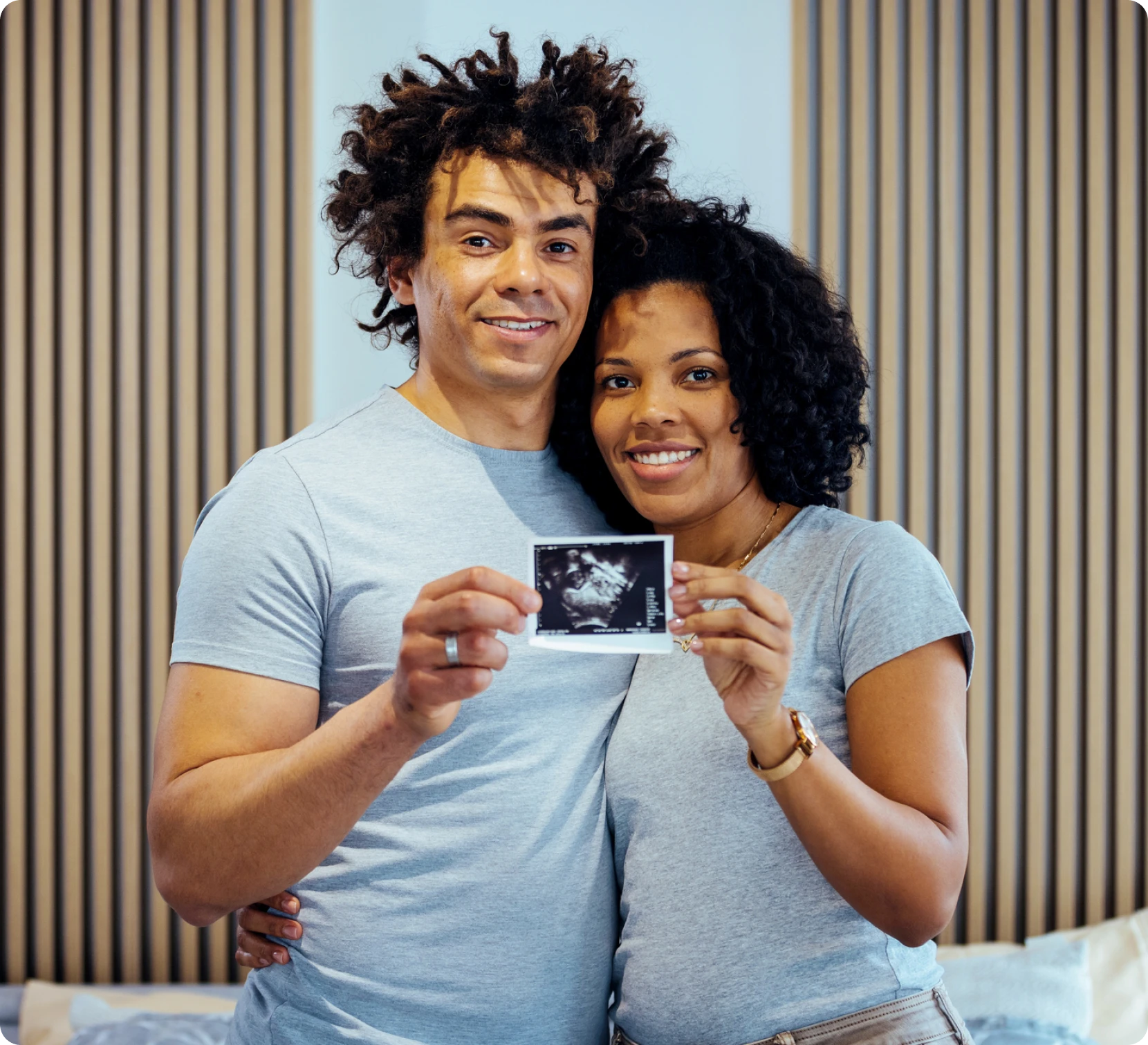Couple holding ultrasound photo, smiling