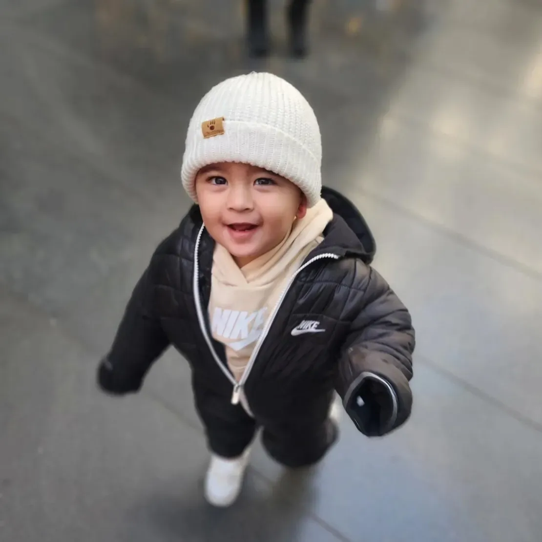 Toddler in winter clothing, smiling brightly