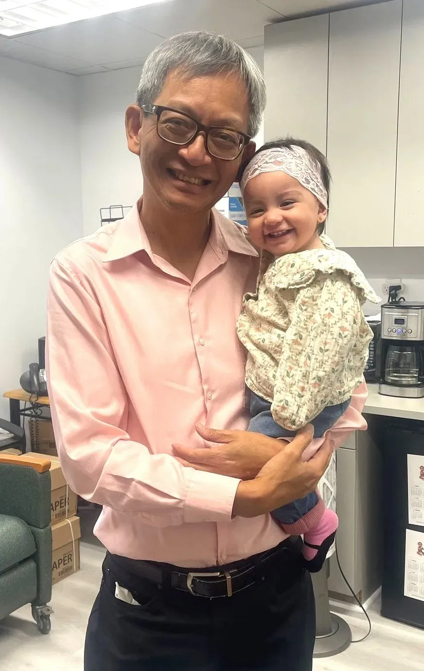 Man holding smiling baby in office