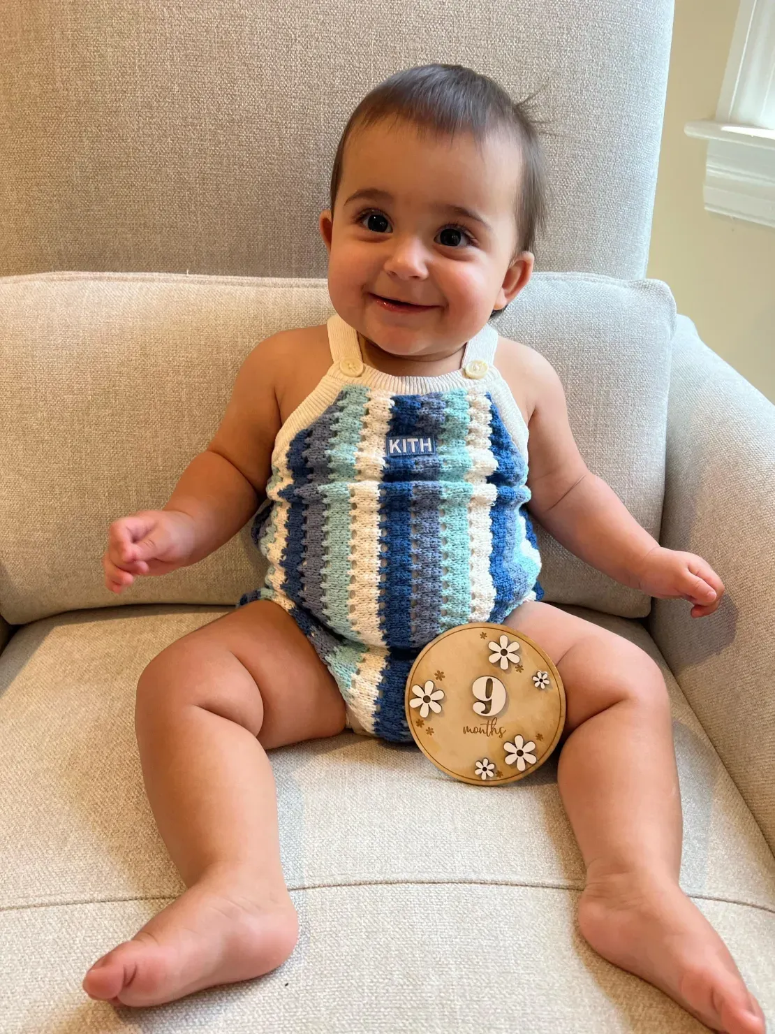 Baby sitting with milestone card