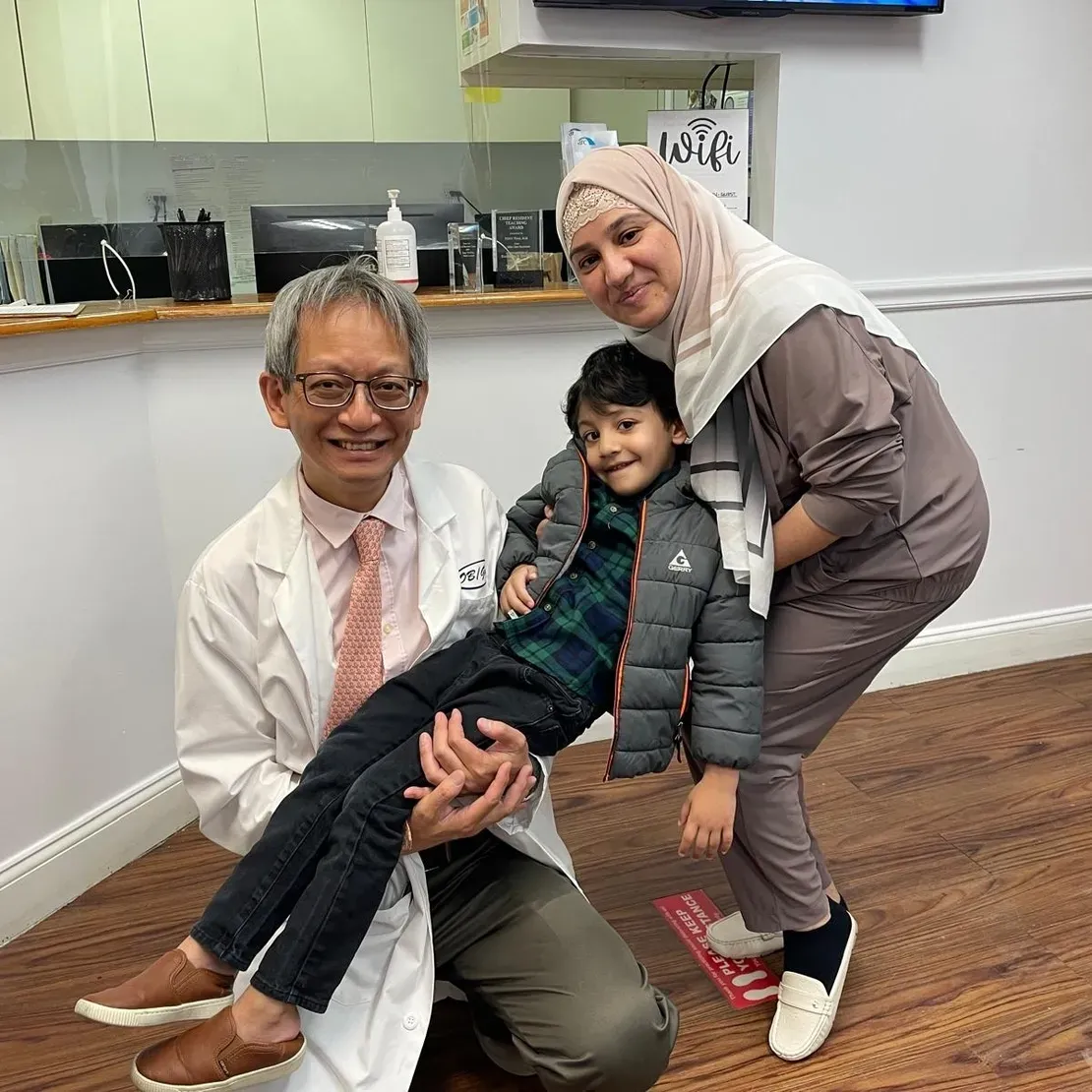 Doctor with smiling family in clinic