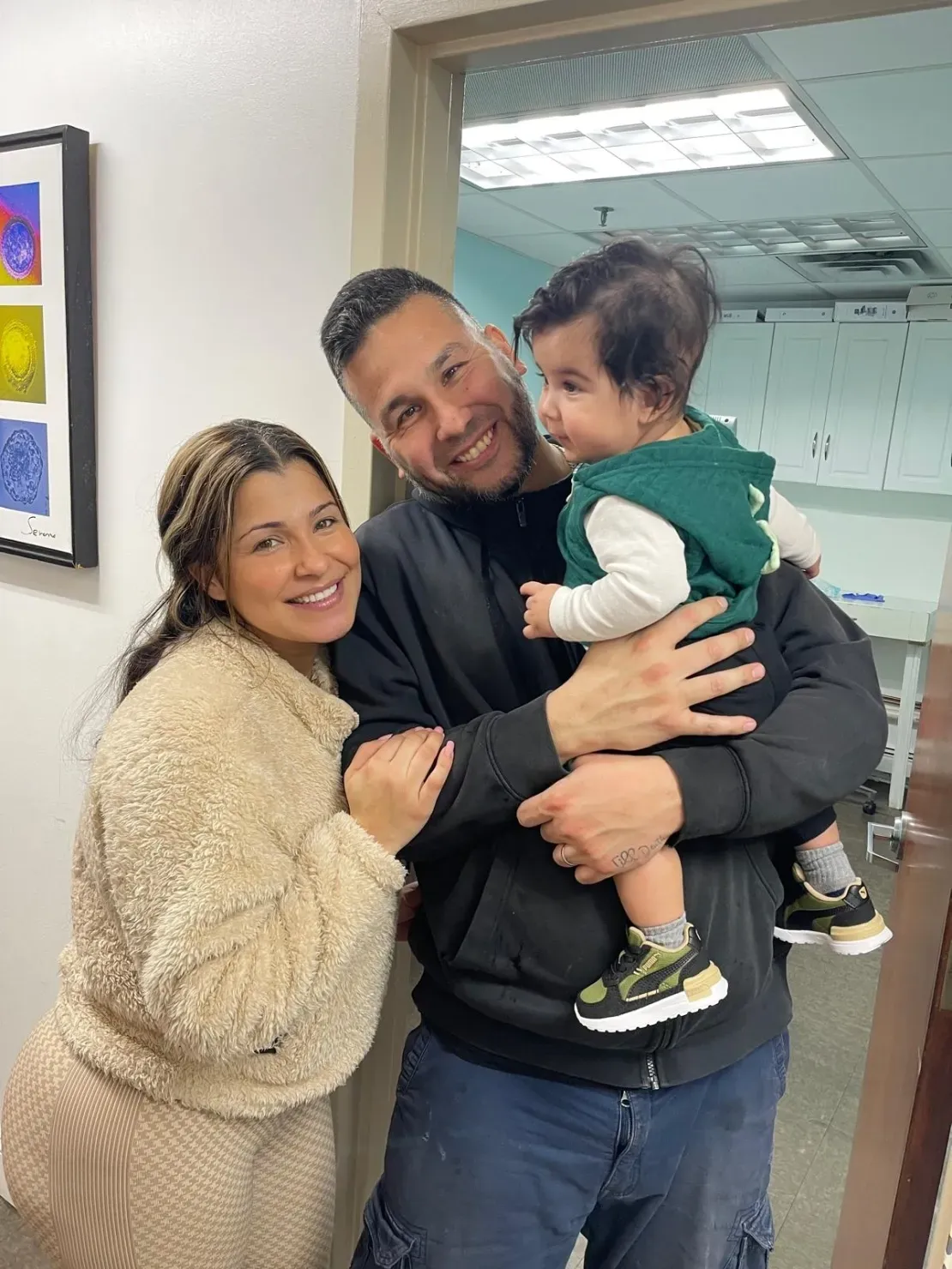 Happy couple holding their baby