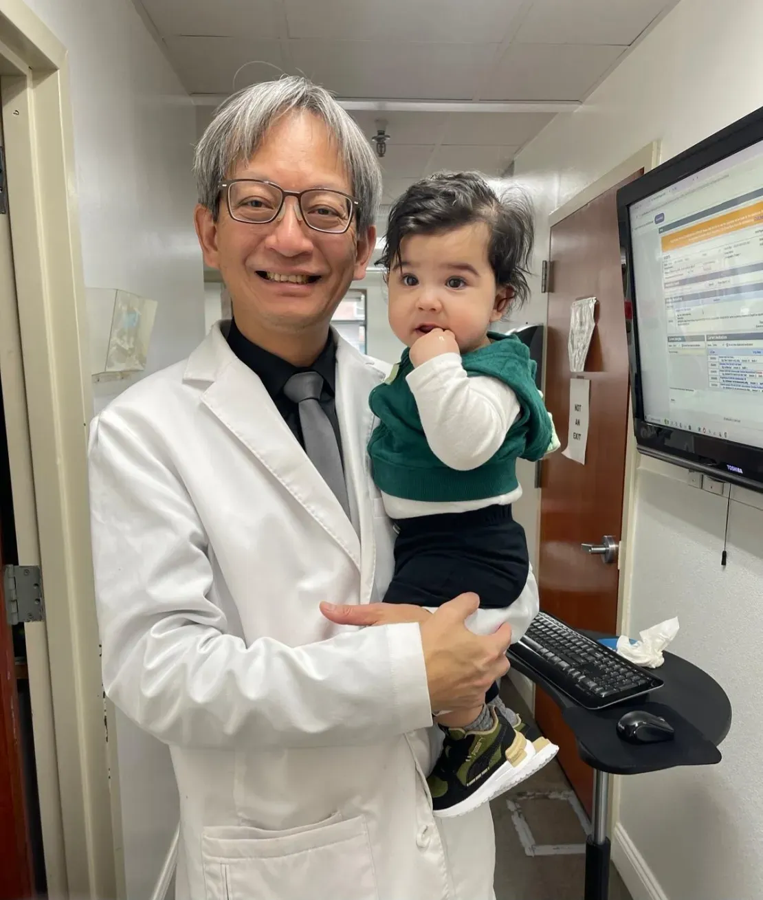 Physician and toddler posing together
