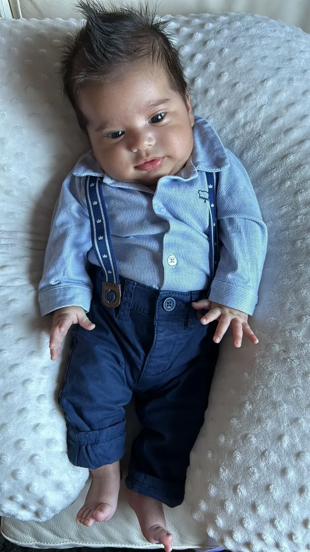 Cute infant wearing suspenders and shirt