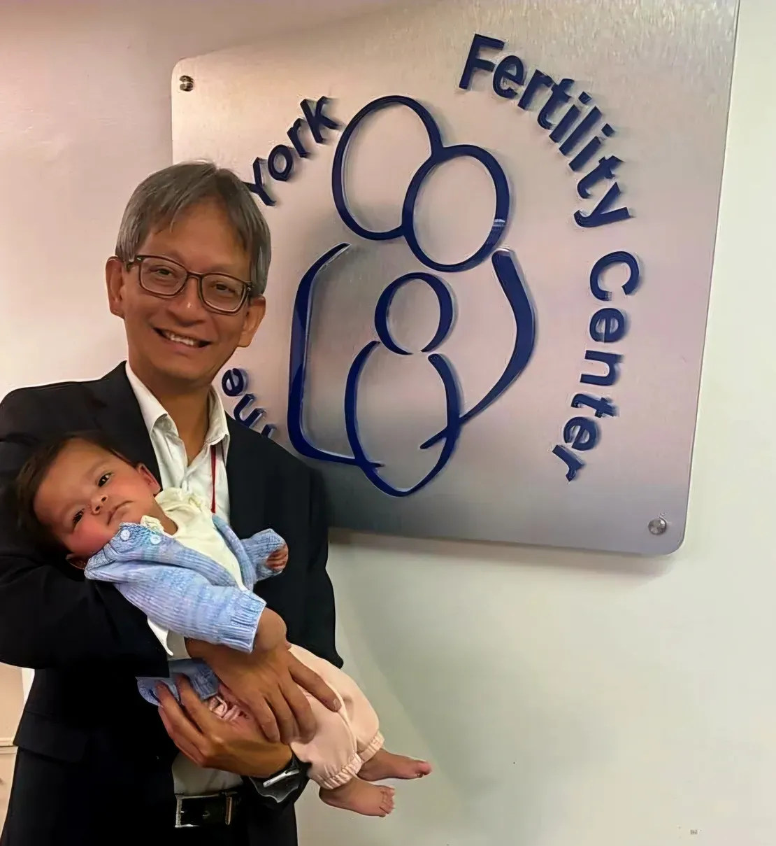 Smiling man with infant in office