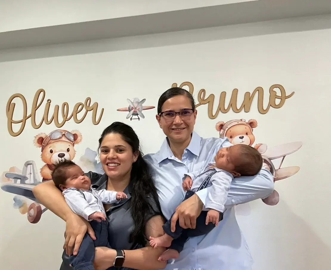 Family with twin newborns smiling together