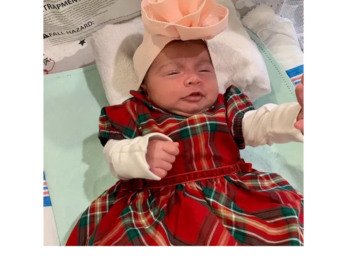 Infant wearing festive outfit and floral headband