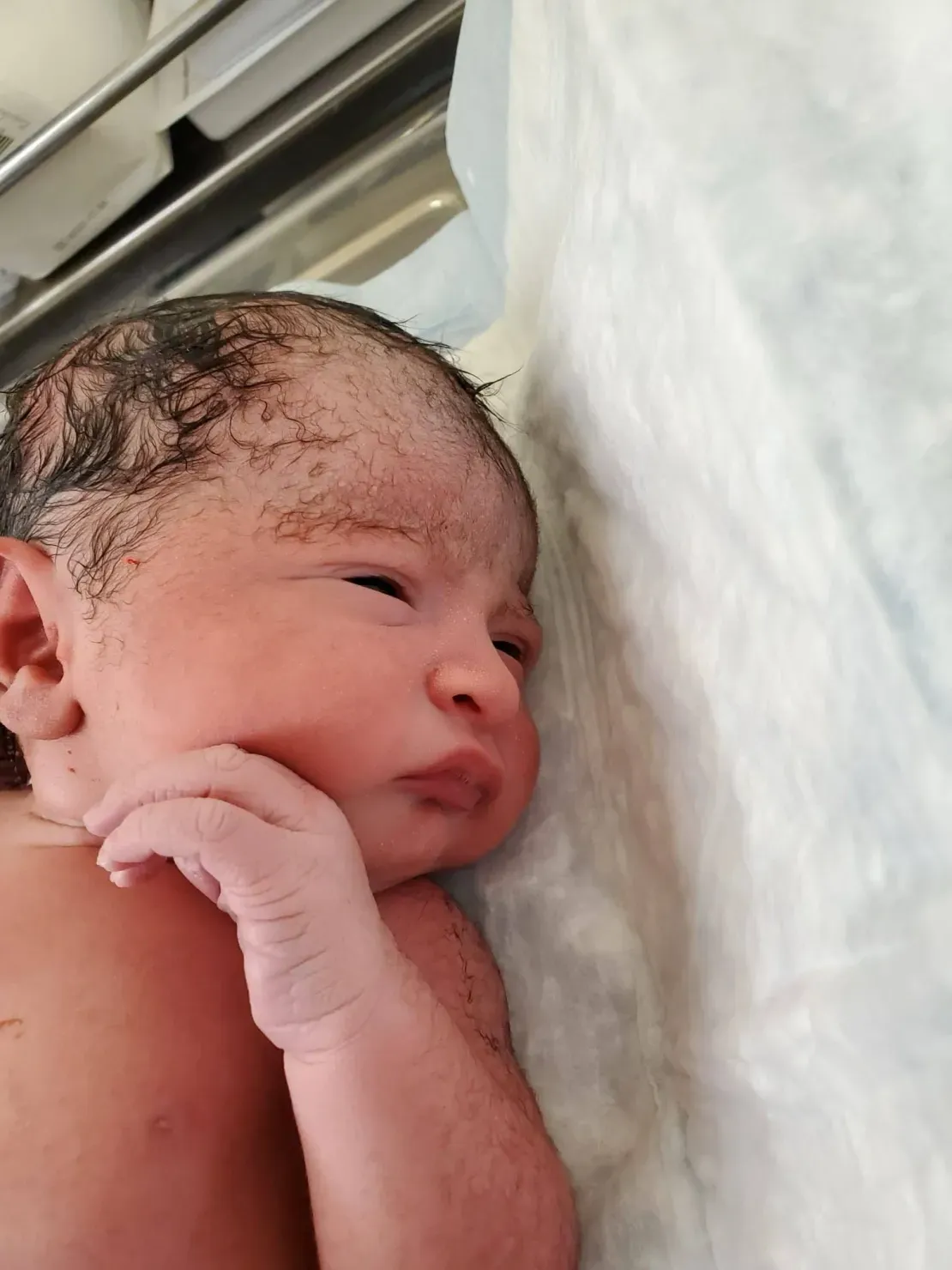 Infant with wet hair after birth